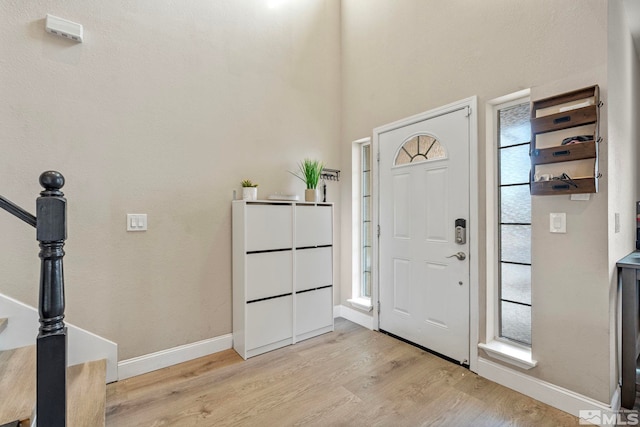 foyer entrance featuring plenty of natural light, light wood-style floors, and baseboards