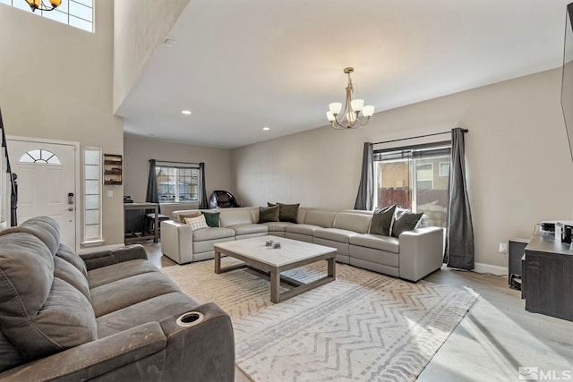 living room with recessed lighting, light wood-type flooring, baseboards, and a chandelier