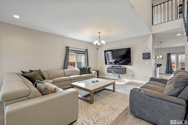 living area featuring recessed lighting, light wood-type flooring, baseboards, and a chandelier