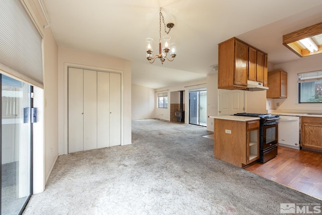 kitchen featuring light colored carpet, black gas range, brown cabinetry, and white dishwasher