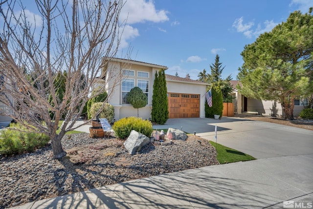 view of front of home featuring an attached garage, driveway, and stucco siding