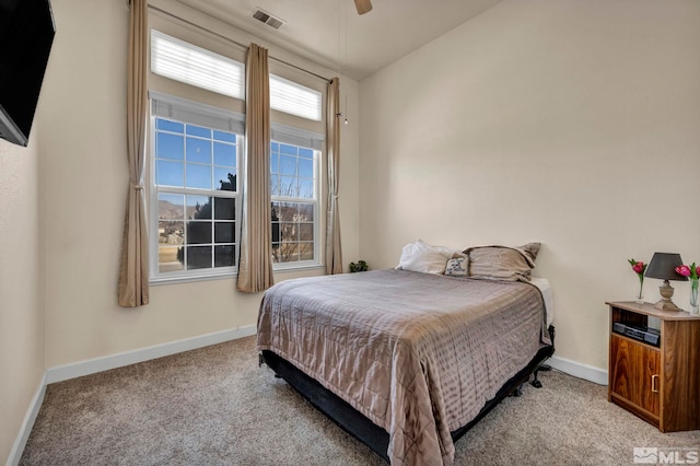 bedroom with visible vents, baseboards, light colored carpet, and a ceiling fan