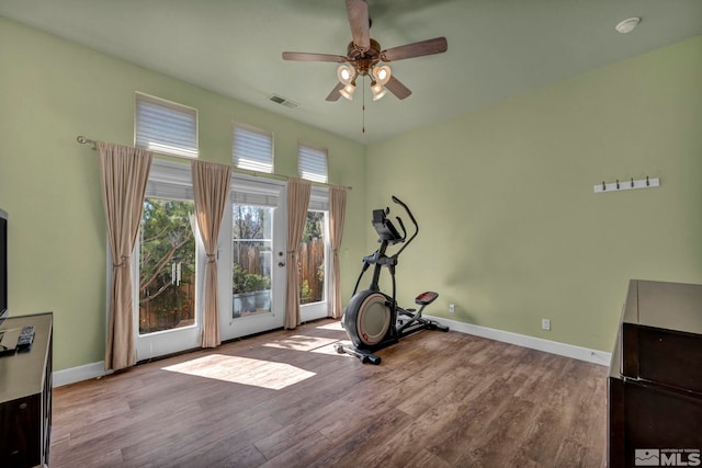 exercise area with a ceiling fan, wood finished floors, visible vents, and baseboards