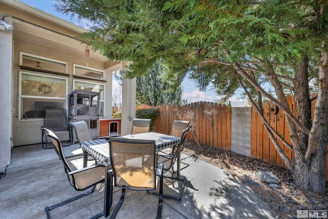 view of patio featuring outdoor dining space and fence