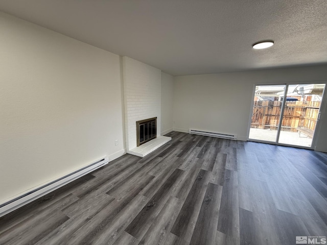 unfurnished living room featuring a baseboard radiator, a textured ceiling, a brick fireplace, and dark wood finished floors