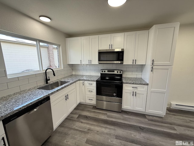 kitchen featuring a sink, stainless steel appliances, tasteful backsplash, and dark wood-style flooring