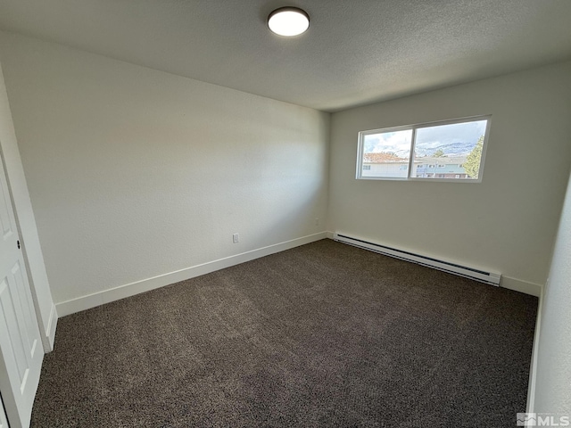 spare room with dark carpet, baseboards, baseboard heating, and a textured ceiling