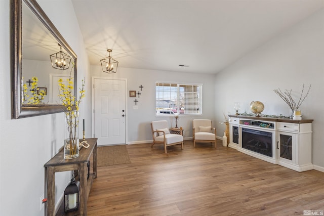 foyer with wood finished floors, visible vents, and baseboards