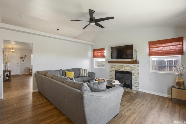 living room featuring a fireplace, lofted ceiling, wood finished floors, and baseboards