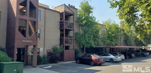 view of property with covered and uncovered parking