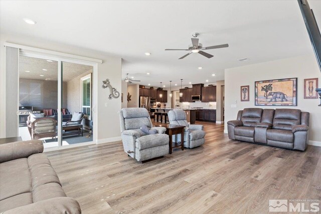 living room featuring visible vents, light wood-style flooring, a ceiling fan, recessed lighting, and baseboards