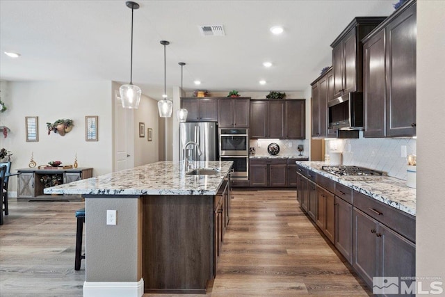 kitchen featuring visible vents, a sink, dark wood finished floors, appliances with stainless steel finishes, and dark brown cabinets