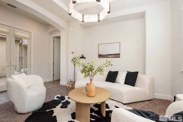 living room with visible vents, arched walkways, and baseboards