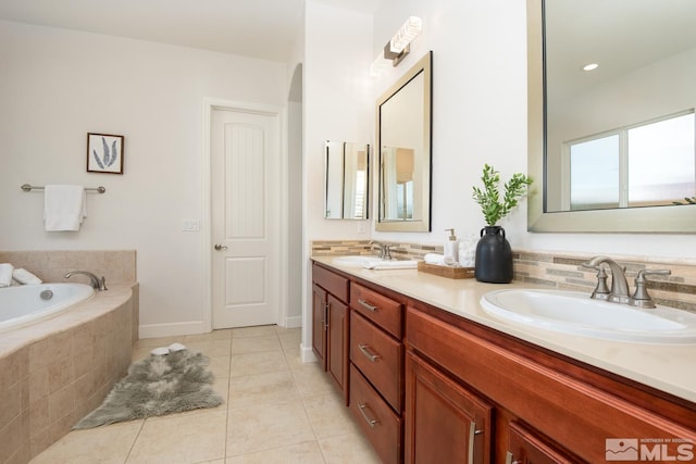 full bath featuring decorative backsplash, a garden tub, tile patterned floors, and a sink