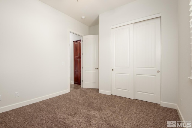 unfurnished bedroom with a closet, baseboards, and carpet floors