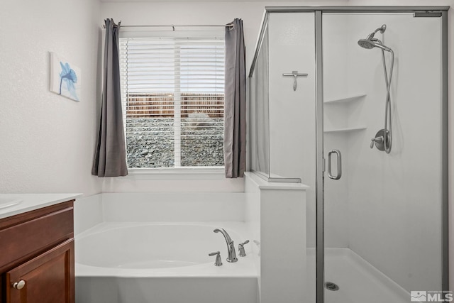 bathroom with vanity, a bath, and a shower stall