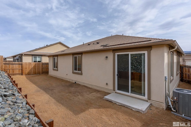 back of house featuring a patio area, central AC unit, fence, and stucco siding