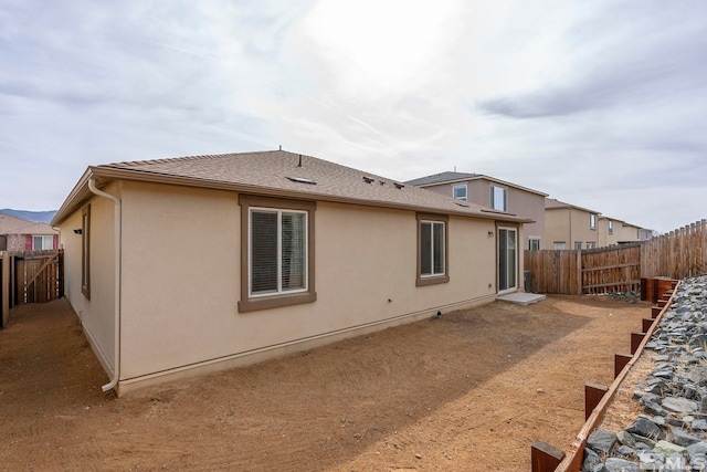 rear view of property with stucco siding and a fenced backyard