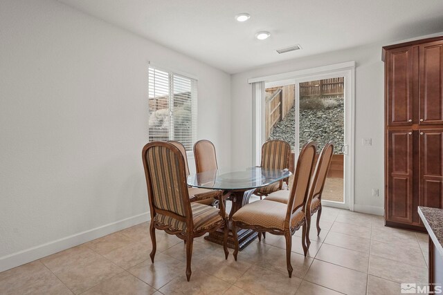 dining space featuring light tile patterned floors, visible vents, and baseboards