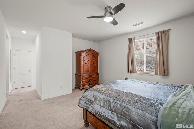 bedroom featuring visible vents, light colored carpet, baseboards, and ceiling fan