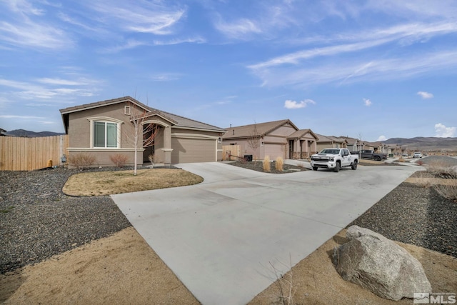 view of front of property with stucco siding, driveway, a garage, and fence