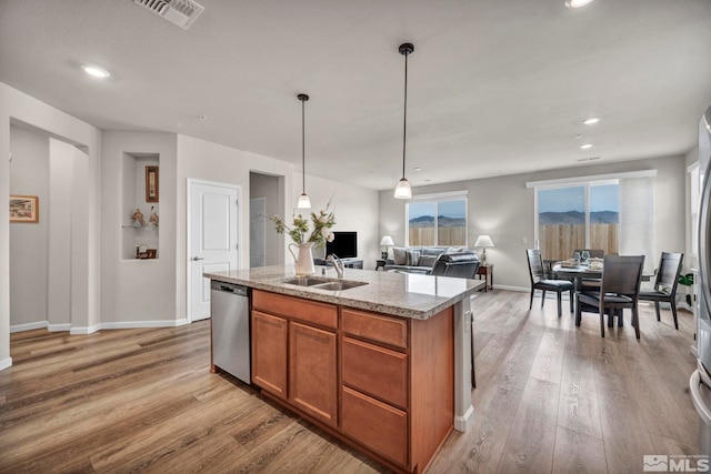 kitchen with visible vents, brown cabinets, light wood-style flooring, a sink, and dishwasher