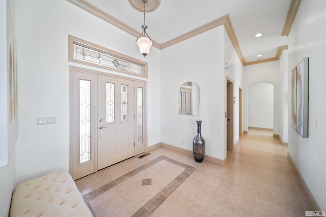 entryway featuring arched walkways, recessed lighting, baseboards, and ornamental molding