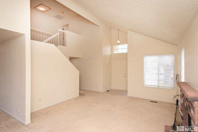 living area featuring carpet, visible vents, high vaulted ceiling, stairs, and a textured ceiling