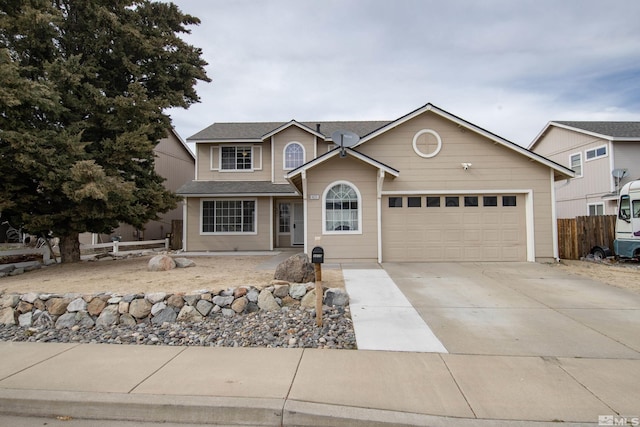 traditional-style home with concrete driveway, a garage, and fence