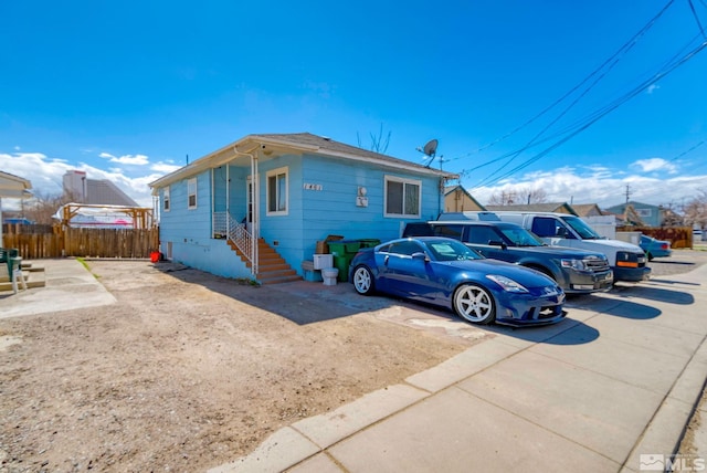 view of front of property featuring crawl space, driveway, and fence