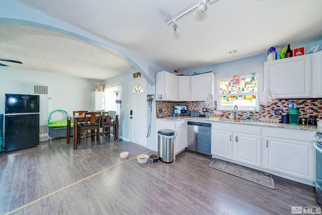 kitchen featuring visible vents, backsplash, wood finished floors, stainless steel appliances, and arched walkways