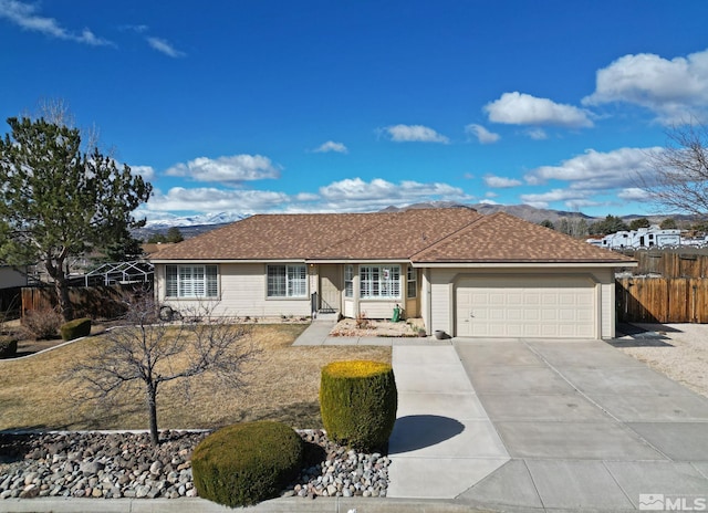 ranch-style house featuring a garage, driveway, and fence