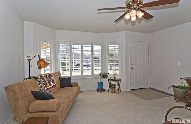 living room with baseboards, carpet floors, and a ceiling fan