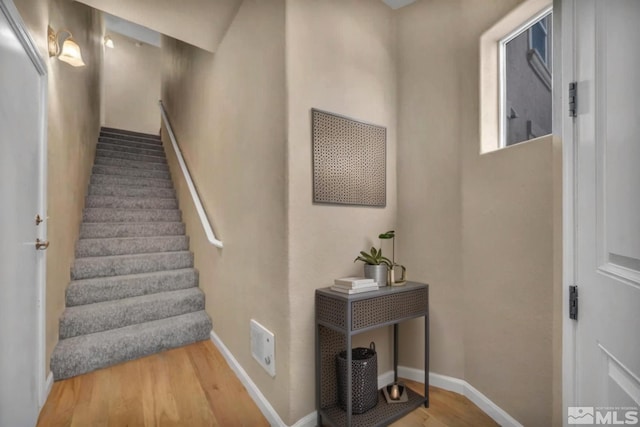 stairway featuring baseboards and wood finished floors