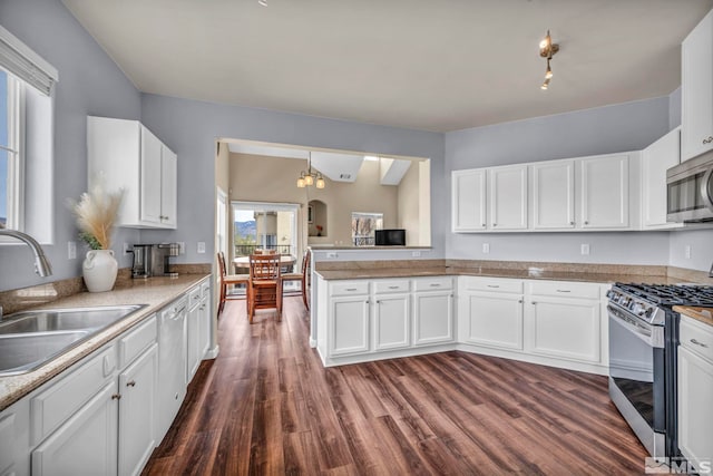 kitchen with a sink, stainless steel appliances, dark wood-style floors, and white cabinets