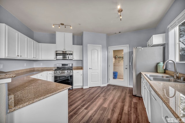 kitchen featuring a sink, white cabinets, dark wood finished floors, and stainless steel appliances