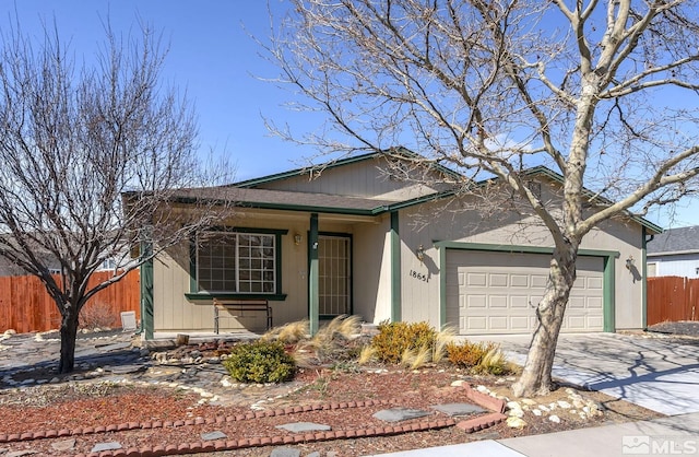 ranch-style house with an attached garage, fence, and driveway