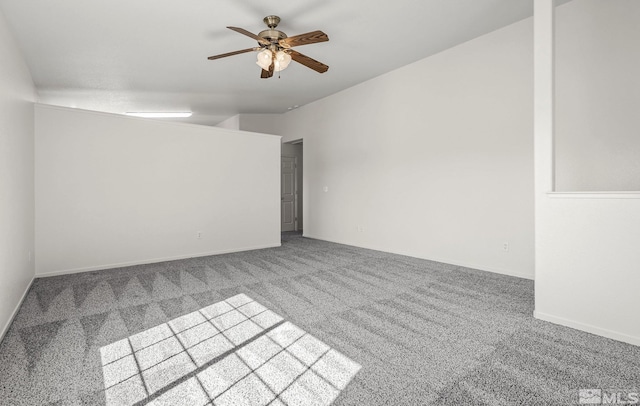 carpeted empty room featuring baseboards and a ceiling fan