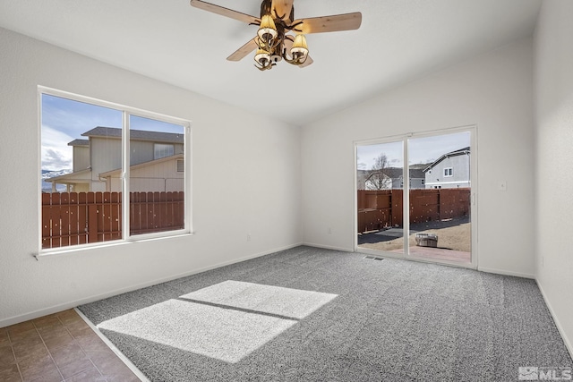 unfurnished room featuring vaulted ceiling, a ceiling fan, baseboards, and carpet floors