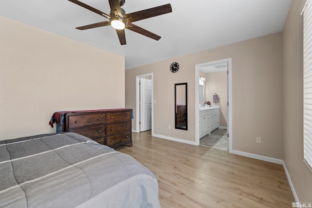 bedroom with light wood-type flooring, baseboards, ensuite bath, and a ceiling fan