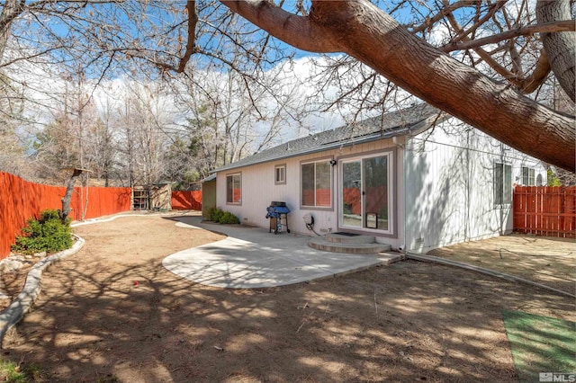 rear view of property with entry steps, a patio, a fenced backyard, and roof with shingles