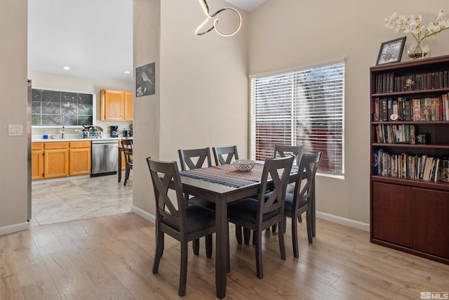 dining space with a healthy amount of sunlight, light wood-type flooring, and baseboards