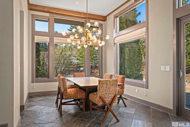 dining room with a chandelier, baseboards, and stone tile flooring