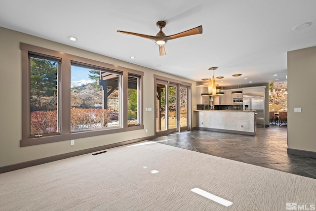 unfurnished living room featuring recessed lighting, visible vents, baseboards, and stone tile floors