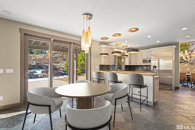 dining area with stone tile flooring, recessed lighting, and baseboards