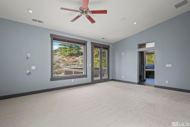 carpeted empty room featuring visible vents, lofted ceiling, and baseboards