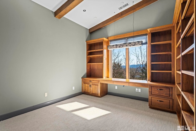 unfurnished office with visible vents, baseboards, built in study area, lofted ceiling with beams, and light colored carpet