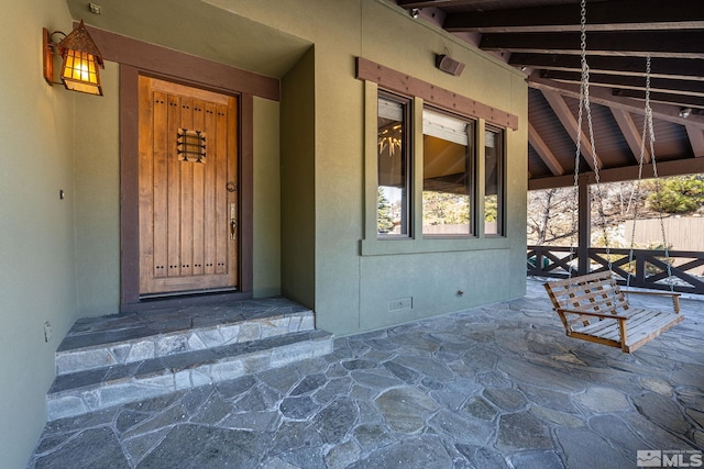 doorway to property with crawl space and stucco siding