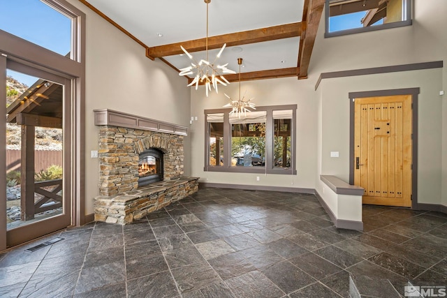 unfurnished living room with visible vents, baseboards, beam ceiling, a fireplace, and a towering ceiling