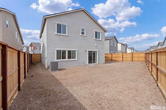 back of house with a residential view, stucco siding, cooling unit, and a fenced backyard